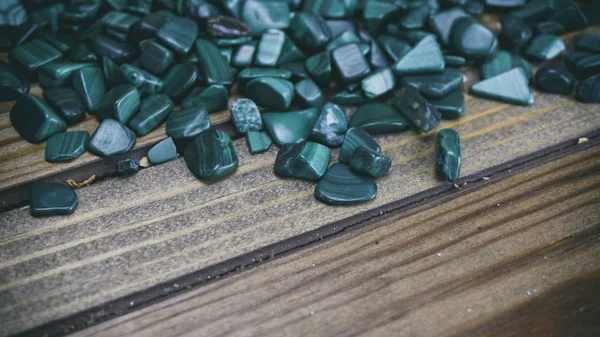 Malaquita sobre fondo de madera, pequeñas conchas sobre fondo de madera — Foto de Stock