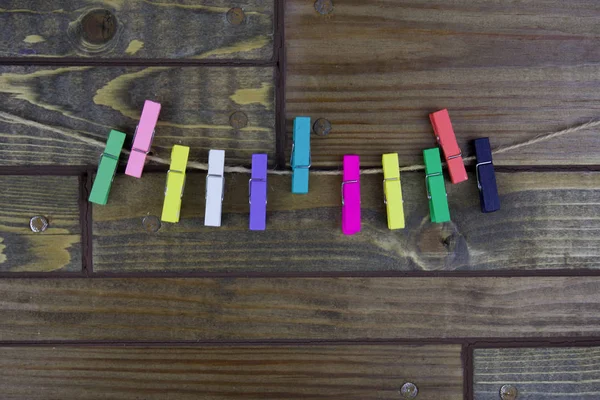 Pinces à linge colorées sur un fond en bois, petits chevilles — Photo
