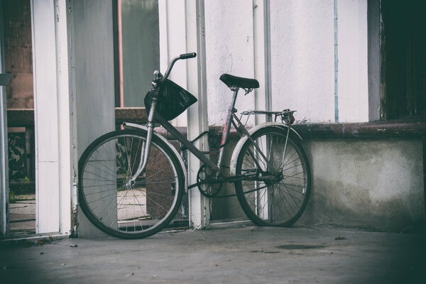 old bicycle standing on the street, from the wheel spokes on a b
