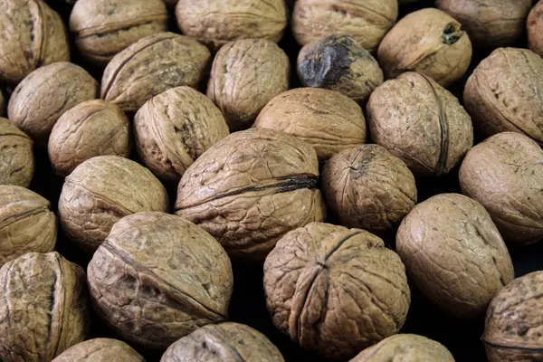 siyah bir arka plan üzerinde birçok ceviz yalan