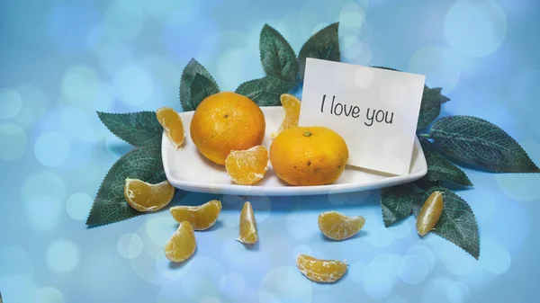 Tangerines with leaves on a blue background, words on paper — Stock Photo, Image