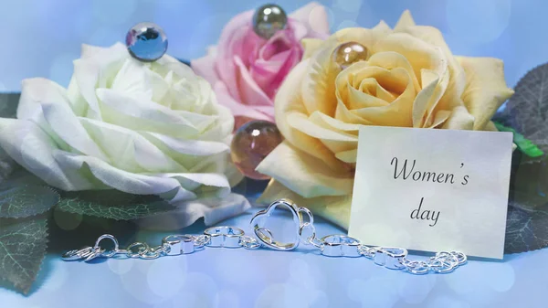 Róże i biżuteria, niebieskim tle, słowa na papierze — Zdjęcie stockowe