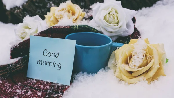 Taza de té en la nieve, una bufanda roja y flores, palabras en papel —  Fotos de Stock