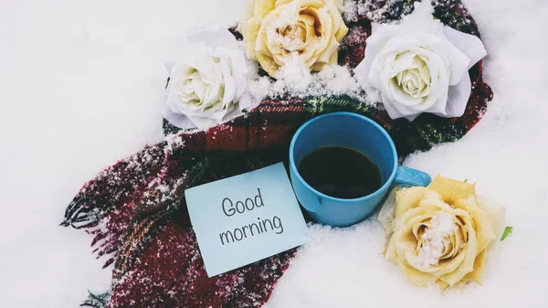 Taza de té en la nieve, una bufanda roja y flores, palabras en papel —  Fotos de Stock