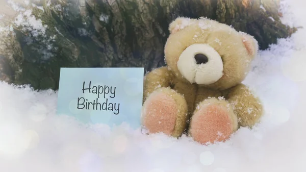 A teddy bear on white snow, words on paper — Stock Photo, Image