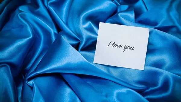 Синя шовкова тканина, записка на папері — стокове фото