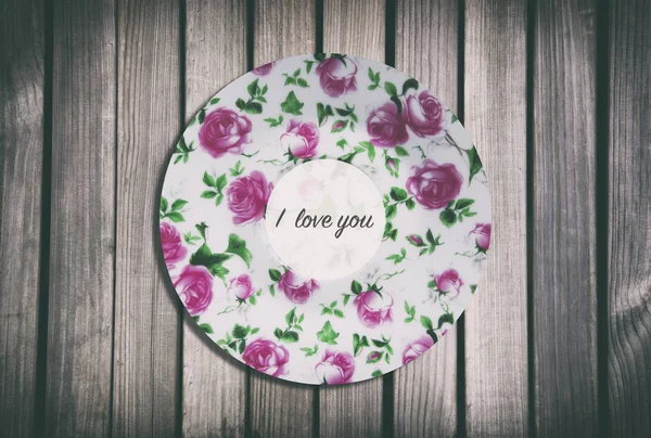 Saucer on a wooden background, words on a white sticker — Stock Photo, Image