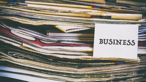 Куча старых газет, слова на бумажной наклейке
