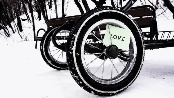 Hjul från barnvagnen i snön, orden på papperet — Stockfoto