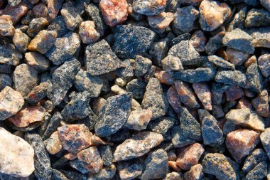 Büyük boyutlu granit ezilmiş taş. Taş biraz pembe ve kırmızı ile gri renktedir. İnşaat yapıları ve yollar için malzeme üretimi. Tarafsız arkaplan, duvar kağıdı.