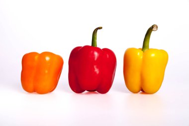 Beyaz arka planda turuncu, kırmızı ve sarı biberler.