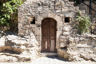 Bir taş bodrum katında bir Yunan ev için eski ahşap kapı.