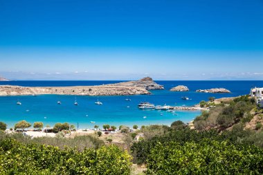 Lindos liman dağın eteklerinde. Lindos akropolisi şehrin üzerinde bir tepe üzerinde yer alır. Koyu ve plajı ile liman.