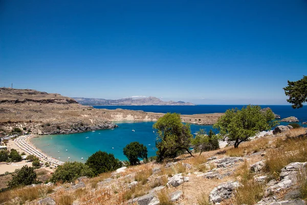 Bahía y orilla de la ciudad de lindos. Agua azul y maravillosas playas de la isla de Rodas . — Foto de Stock