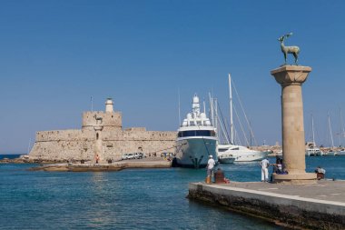 Rodos, Yunanistan, 1 Mayıs, 2018; Heykel geyik ve tazı ve Mandraki Limanı sütunlarda. Arka plan üzerinde Noel Baba kale. Yer nerede heykel, colossus Rhodes üzerinden yapıldı. Liman için sembolik kapısı.