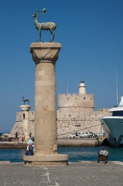 Rodos, Yunanistan, 1 Mayıs, 2018; Heykel geyik ve tazı ve Mandraki Limanı sütunlarda. Arka plan üzerinde Noel Baba kale. Yer nerede heykel, colossus Rhodes üzerinden yapıldı. Liman için sembolik kapısı.