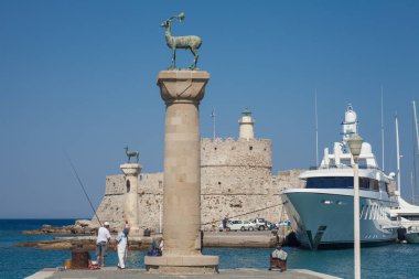 Rodos, Yunanistan, 1 Mayıs, 2018; Heykel geyik ve tazı ve Mandraki Limanı sütunlarda. Arka plan üzerinde Noel Baba kale. Yer nerede heykel, colossus Rhodes üzerinden yapıldı. Liman için sembolik kapısı.