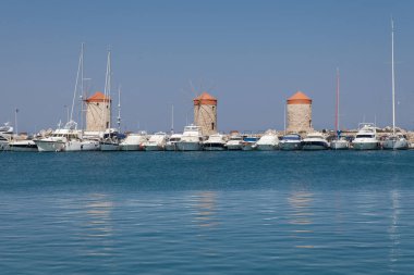 Rodos, Yunanistan, 1 Mayıs, 2018; Yel değirmeni Papagiorg katiyen Vati Rhodes Harbor. Eski savunma standları ve yel değirmenleri. Wharf limanları, tekneler ve gemiler yelken. Tarihi iskele ve Plajı.