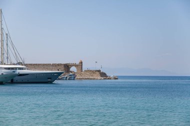 Liman ve Rodos anıtlar. Eski savunma standları ve yel değirmenleri. Wharf limanları, tekneler ve gemiler yelken. Tarihi liman, iskele ve Plajı.