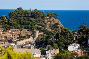 View of the town of Tossa de mar one of the most beautiful towns on the Costa Brava. City walls and medieval castle on the hill. Amazing city in Girona, architecture and monuments of Catalonia. clipart