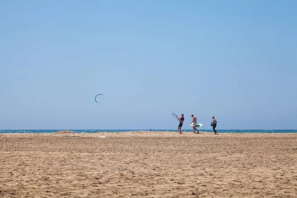 Люди занимаются кайтсерфингом. Пляж на полуострове Прасониси, Родос. Красочные воздушные змеи на берегу моря. Синее море и виндсерфинг. — стоковое фото