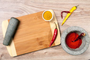 Kırmızı ve sarı biber kesme tahtası üzerinde. Ahşap mutfak masası. Ahşap arka plan. Sarı habanero ve taze fesleğen yaprağı. Gümüş çatal.