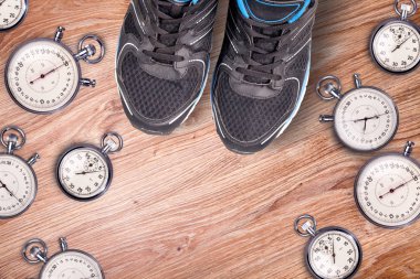 Ekipman çalıştırıyor. Kronometre ve erkek ayakkabı çalışan. Çalışma zamanı. Spor aksesuarları ahşap zemin üzerinde çalışan. Spor rekabet. Birlikte çalışan serin.
