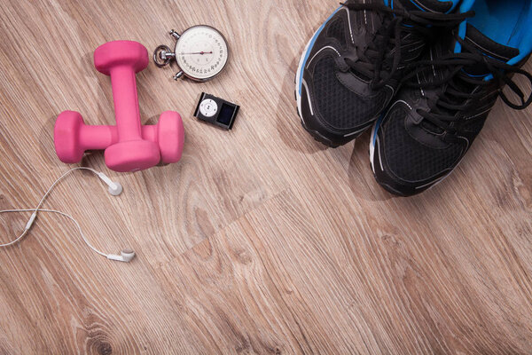 Тренажерный зал и тренажерный зал. Секундомер и кроссовки, скакалка и музыкальный проигрыватель. Пора тренироваться. Аксессуары для бега на деревянном полу
.