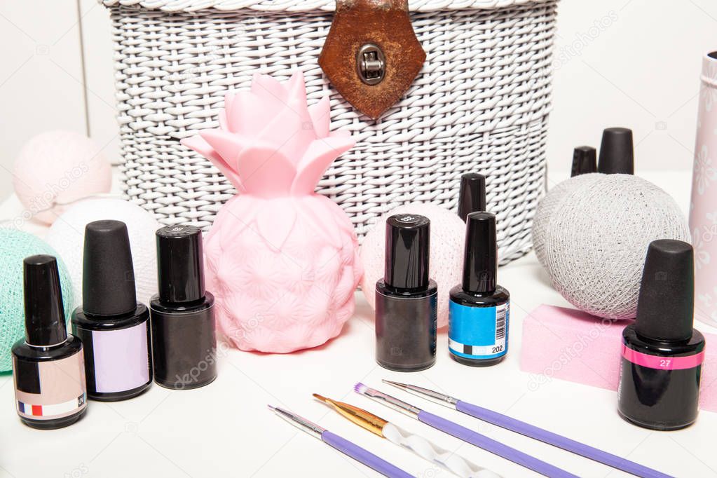 Accessories for nail decoration on a white table. Varnishes and nail brushes on the manicure table.