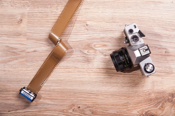 Old photo camera and film, exposure meter and retro analog camera on wood background.