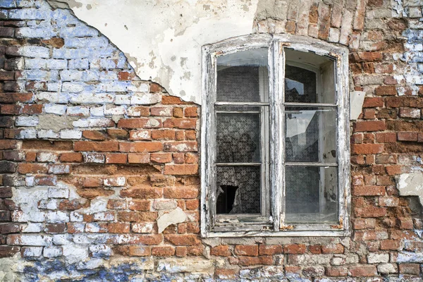 Old brick wall and wooden broken window. A broken window in an old house.