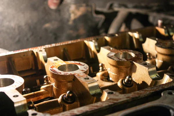 Open block of four cylinder petrol engine. The cylinder head in the workshop.