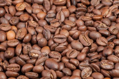 Kahve çekirdekleri masanın üzerine dağılmış. Doku siyah kahve taneleri üzerinden. Duvar duvar dağınık kahve.