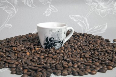 Küçük fincan espresso ve kahve çekirdekleri kalbinde. Bir bardakta bir utanç tablosu.