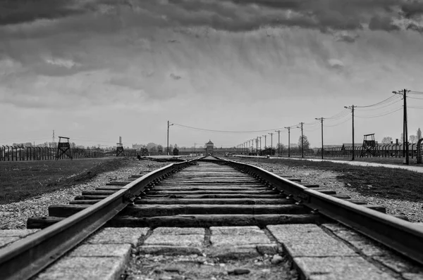 AUSCHWITZ, POLONIA - 18 de abril de 2018; Museo Conmemorativo del Holocausto. Museo Auschwitz - Birkenau. Entrada principal al campo de concentración. Alambre de espino alrededor de un campo de concentración. Barak Canadá . — Foto de Stock