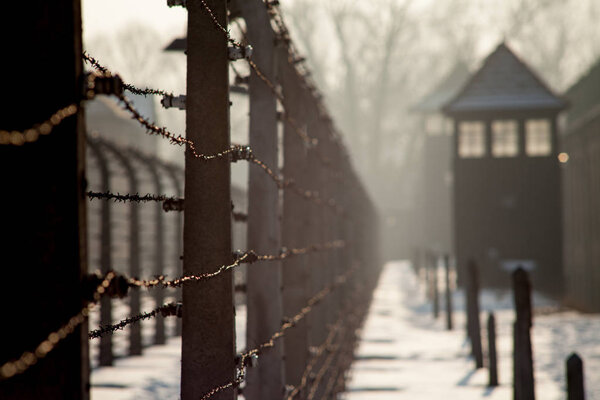 AUSCHWITZ, POLAND - FEBRUARY 23, 2018 ; Museum Auschwitz - Holocaust Memorial Museum. Barbed wire around a concentration camp. Shed guard in the background.