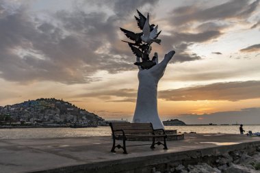 Kusadasi, Türkiye - 17 Eylül 2019: Kuşadası, Türkiye 'de güvercinlerle birlikte barış heykeli eli.