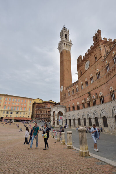 Siena, Italy - October 1, 2016: Tourrists and spectators inside Piazza del Campo in a cloudy day, Siena, region of Tuscany, Italy
