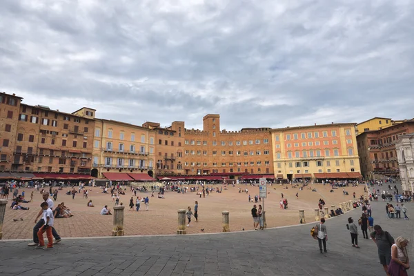 Siena, Italy - October 1, 2016: Tourrists and spectators inside Piazza del Campo in a cloudy day, Siena, region of Tuscany, Italy — стоковое фото