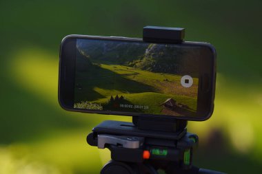 Tripod kayıt timelapse günbatımında kırsal dağ manzara arka plan ile Smartphone