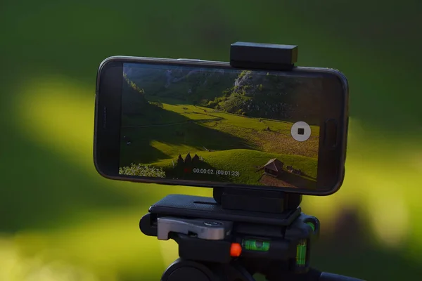 Tripod kayıt timelapse günbatımında kırsal dağ manzara arka plan ile Smartphone