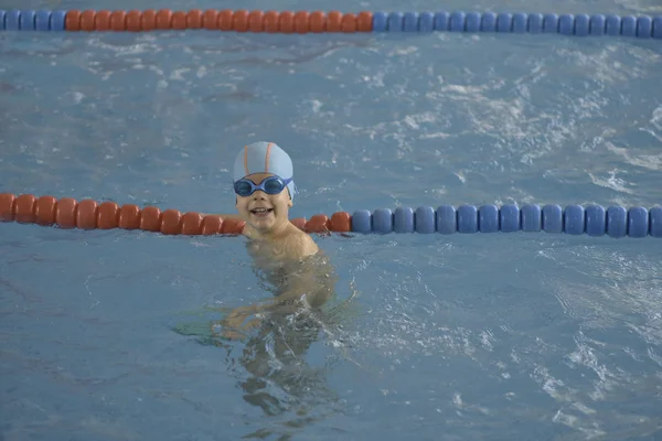 快乐的小男孩，学习在室内游泳池里游泳 — 图库照片