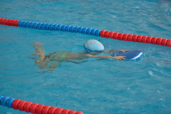 Ευτυχισμένος αγοράκι Μαθαίνοντας να κολυμπήσετε στην εσωτερική πισίνα — Φωτογραφία Αρχείου