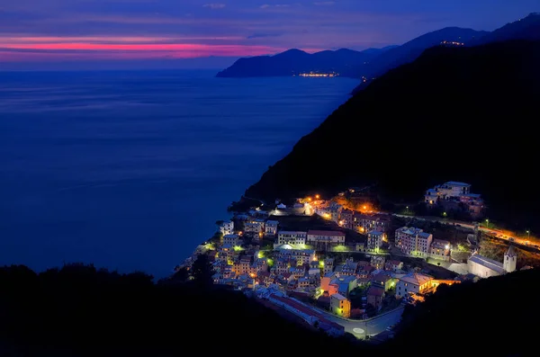 Manarola vista superior para baixo. Vista noturna com luzes da cidade. Cinque Terre costa e mar após o pôr do sol — Fotografia de Stock