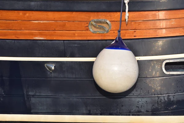 Un parafango (canottaggio) appeso sulla tavola per proteggere il lato della barca a vela dai danni. Italia . — Foto Stock