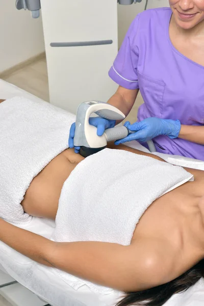 De schoonheidsbehandeling van een jonge vrouw in gespecialiseerde kliniek. Body Trimmer — Stockfoto