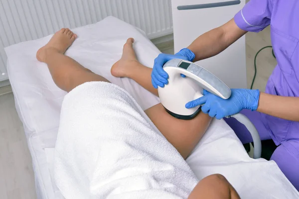 De schoonheidsbehandeling van een jonge vrouw in gespecialiseerde kliniek. Body Trimmer — Stockfoto