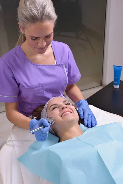 Mooie jonge vrouw krijgt professionele huidbehandeling in een kliniek schoonheid — Stockfoto