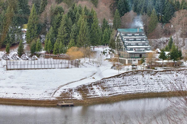 Mountain landscape with a hotel and camping places near a river in winter season