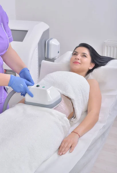 Flot ung kvinde får kryolipolyse fedt behandling i professionelt kosmetisk skab - Stock-foto